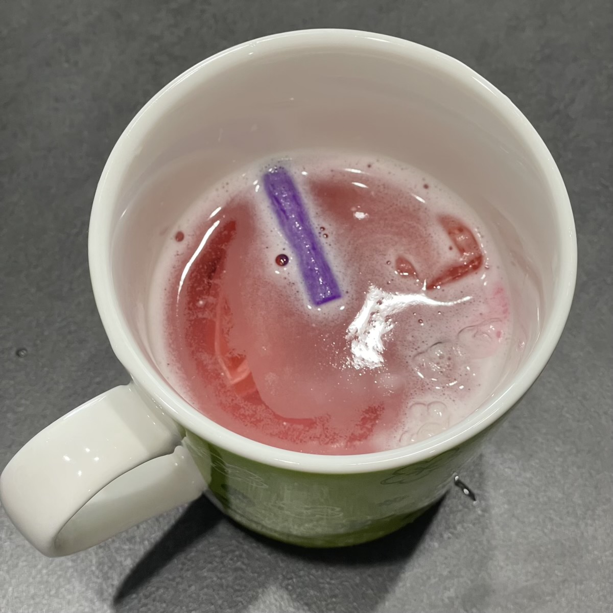 矯正装置をリテーナー洗浄剤を入れたマグカップで洗浄している様子
